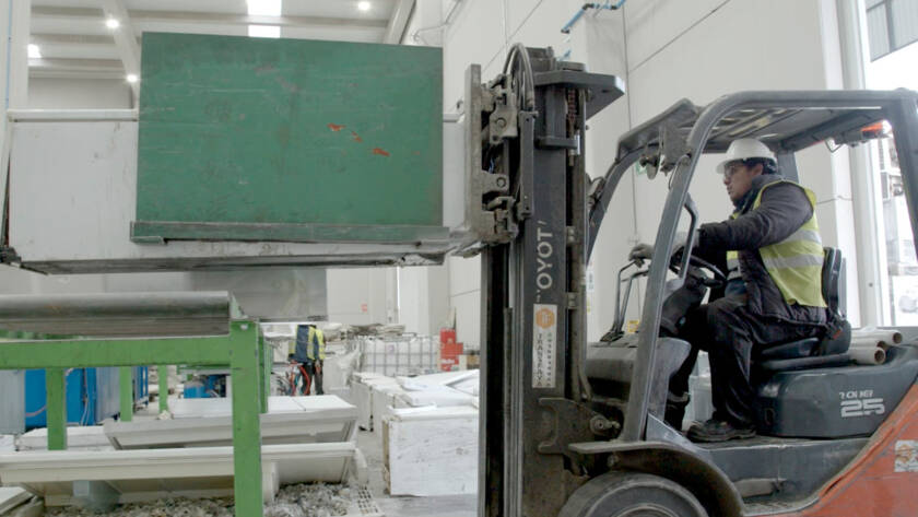 Operario con toro mecánico transportando una nevera hacia la zona de carga de la fragmentadora en la planta de Movilex Barcelona