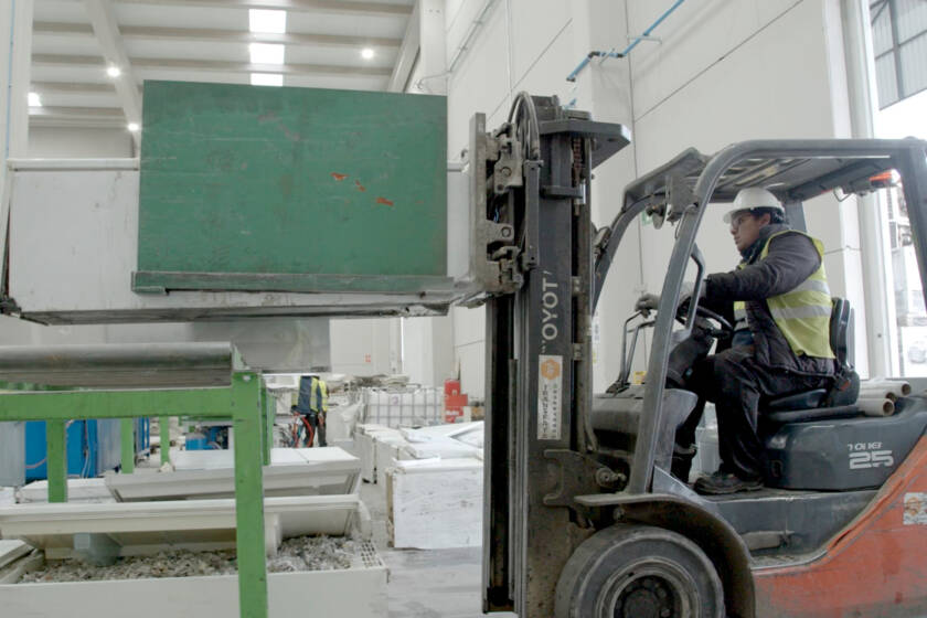 Operario con toro mecánico transportando una nevera hacia la zona de carga de la fragmentadora en la planta de Movilex Barcelona